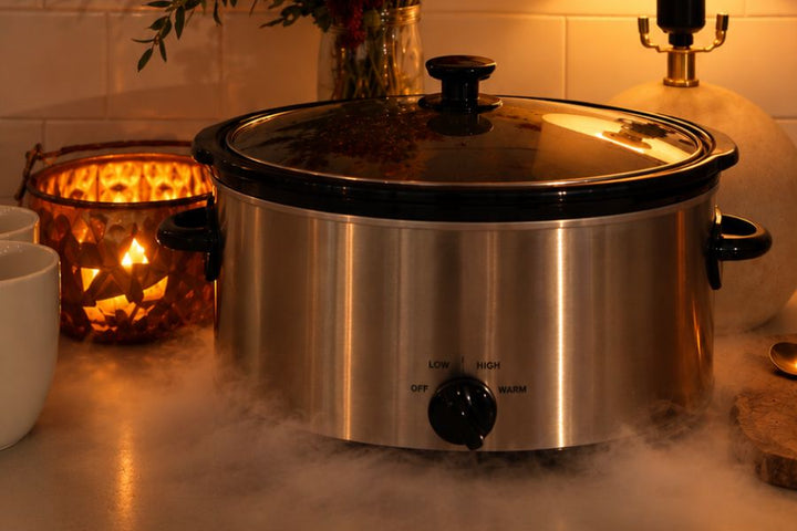A Crockpot surrounded by Halloween decor and dry ice fog. 
