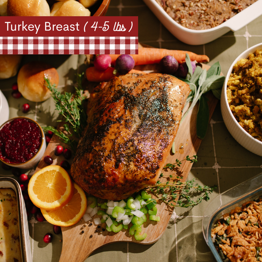 Image of cooked Turkey breast on a wooden cutting board with carrots, oranges, celery and herbs surrounding the turkey all on a green plaid table cloth. A red-and-white gingham banner at the top left reads 'Turkey breast 4-5lbs).'