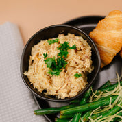 Bowl of chicken with croissant, and green beans on a plate.