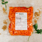 Bag of sliced carrots with a Beehive Meals label on a light background