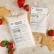 Beehive Meals packages with cheesecake fruit dip and graham crackers on a marble surface