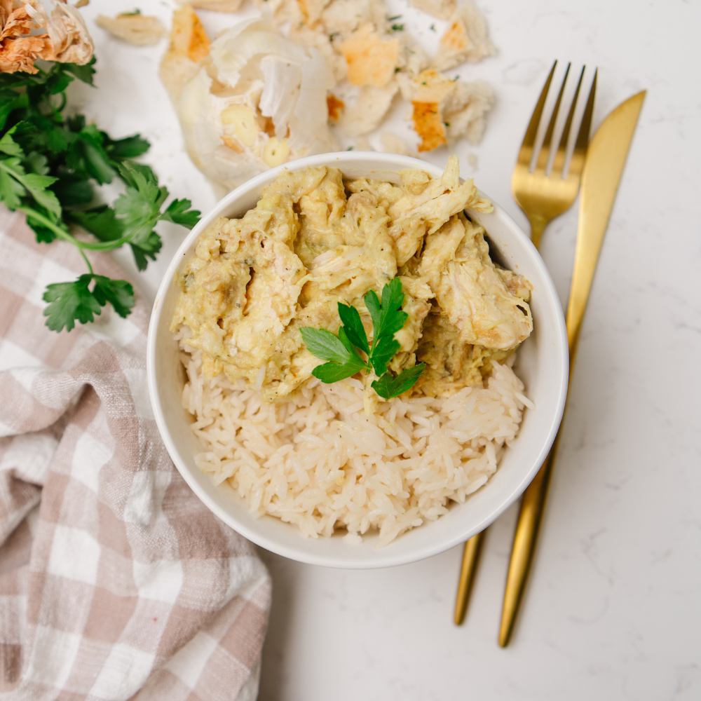 Bowl of creamy chicken and rice with a gold fork on a checkered cloth