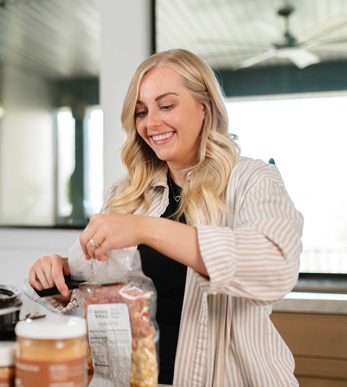 Beehive Meals Founder Allyse Jackson cutting open a Beehive Meals package with scissors