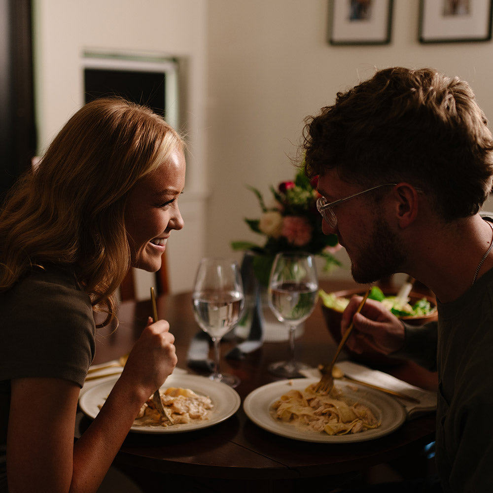 Two people enjoying a meal together at a kitchen table.